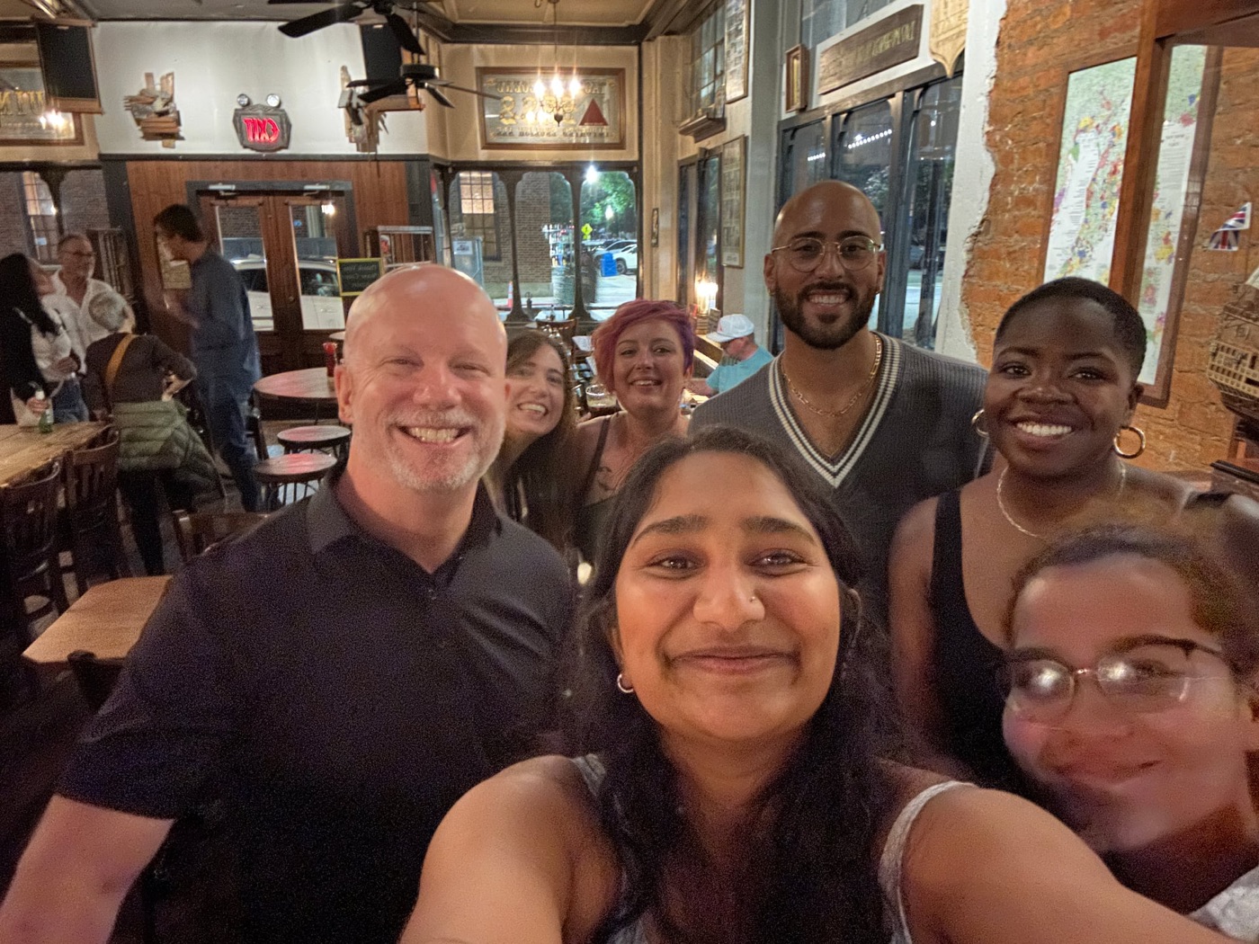 Athens Scoop Dinner Club guests smiling for a group selfie at a restaurant